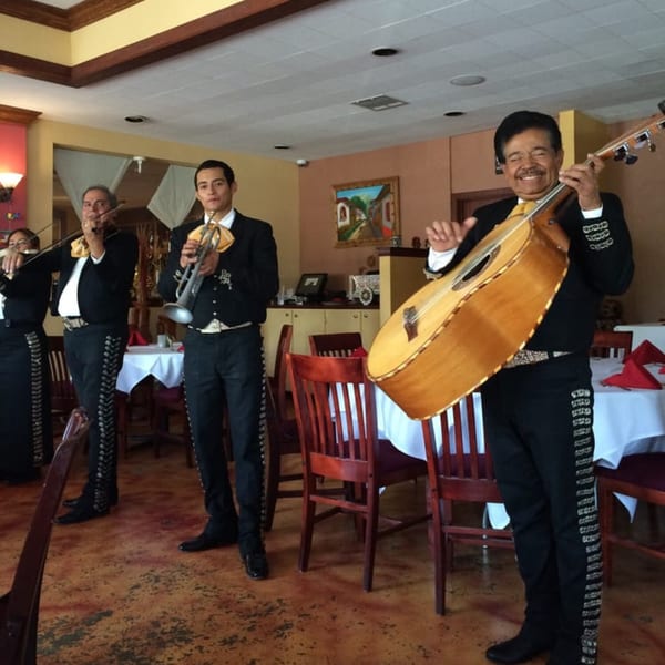 A mariachi band performs inside Guillermo's Restaurante, with musicians playing violin, trumpet, and guitar.