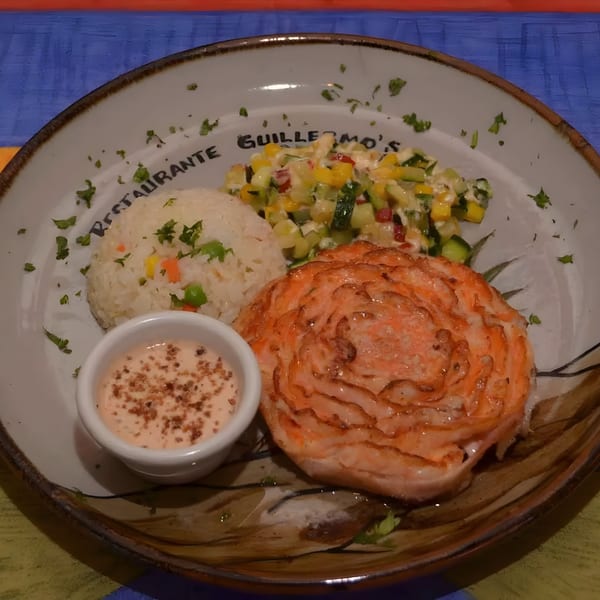 Guillermo's Restaurante salmon dish with rice, corn and zucchini salsa, and a side of sauce.